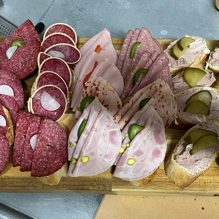Holzplatte mit drei verschiedenen Sorten an Wurstbroten.